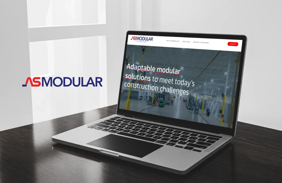 an image of the asmodular website on a laptop on a wooden table