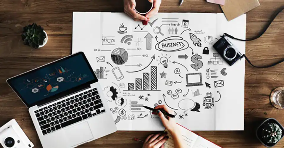 image of a brainstorming and strategy document on a table with a laptop