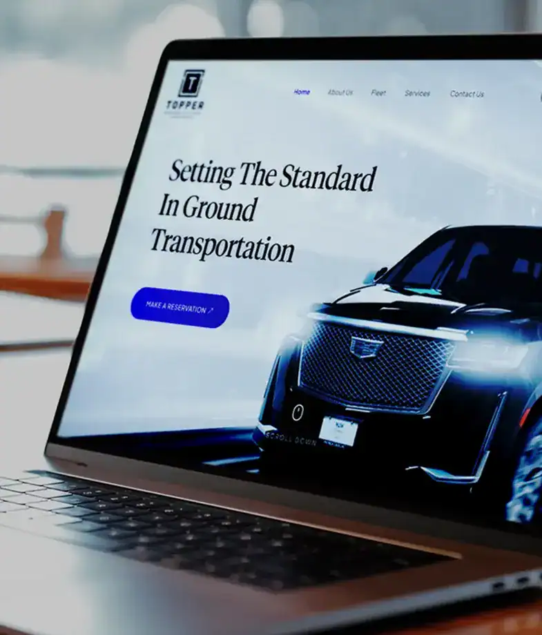 image of the topper limo website n a laptop on a wooden desk