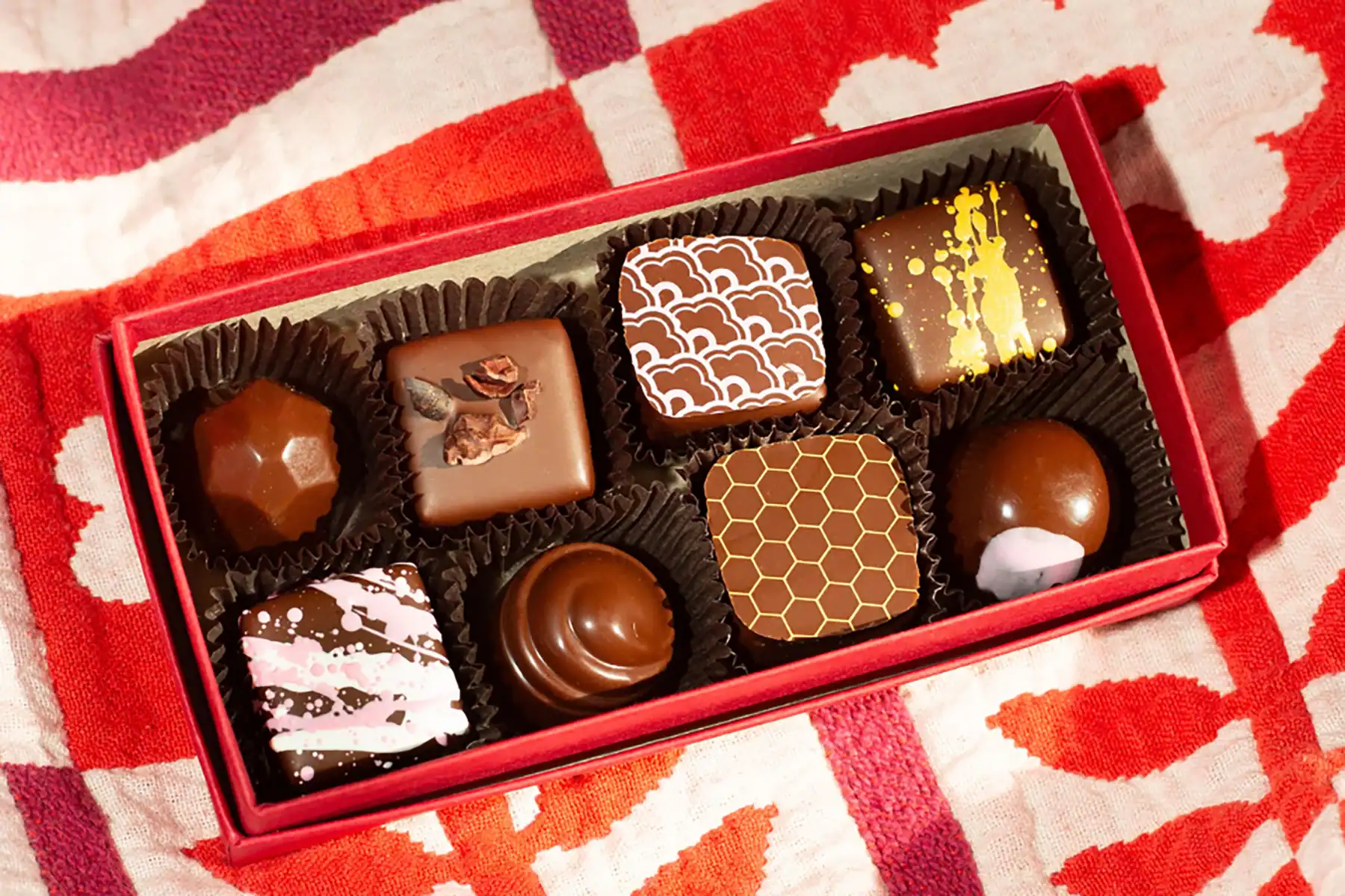 image of chocolate truffles in a box n a red background